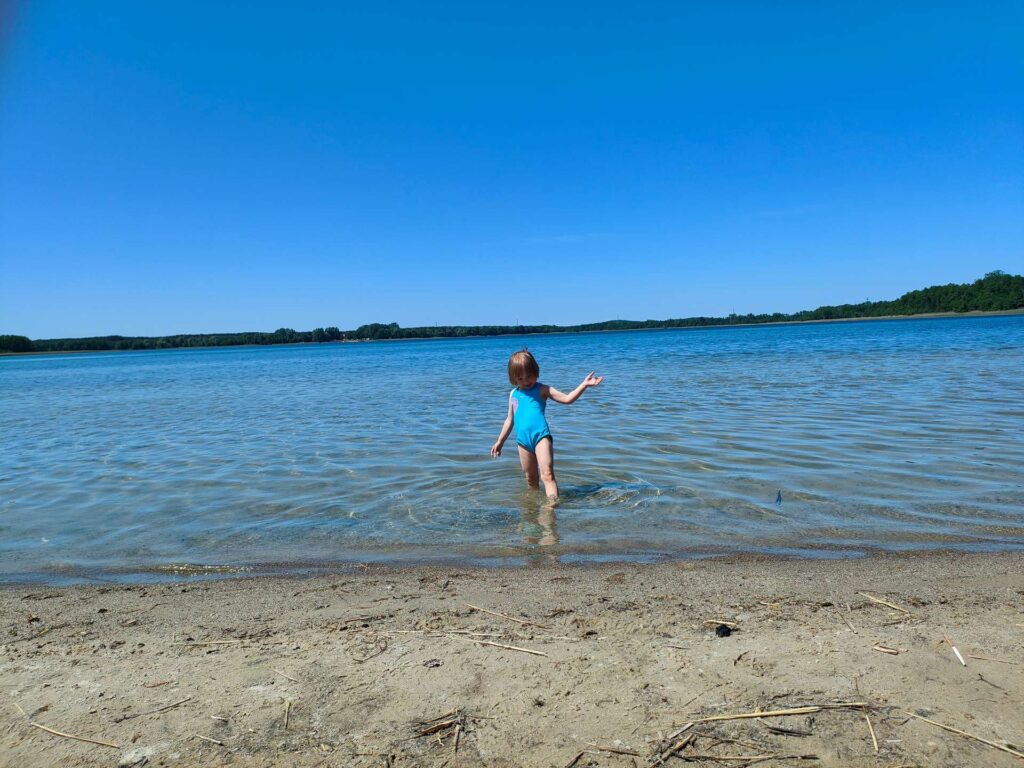 Plaża nad jeziorem - dziecko w wodzie.