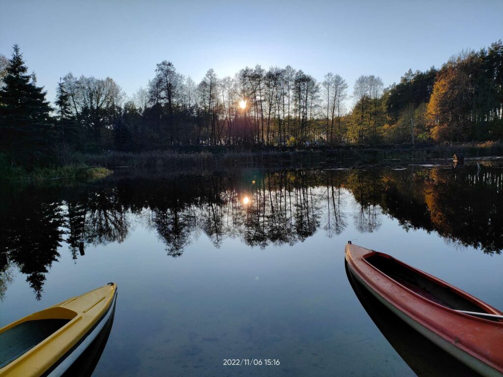 Zachód słońca nad lasem i stawem, agroturystyka, wiejskie życie, wakacje na wsi, slow life.